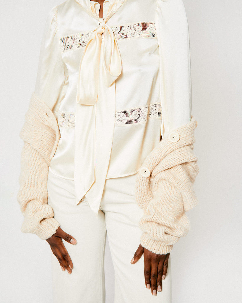 Model wears Bellerose's beige Naneci Cardigan with the off-white Helen Blouse from Shrimps